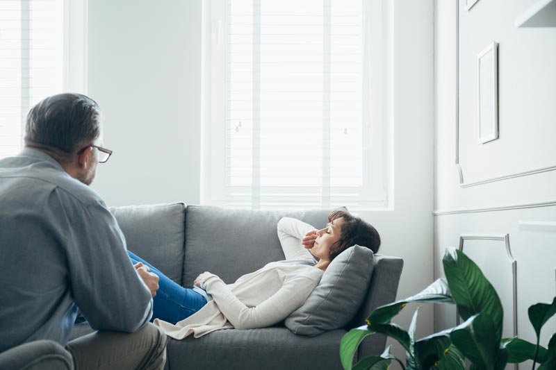 woman-at-therapy-room-laying-on-couch-discussing-w-UG75Z2Y.jpg