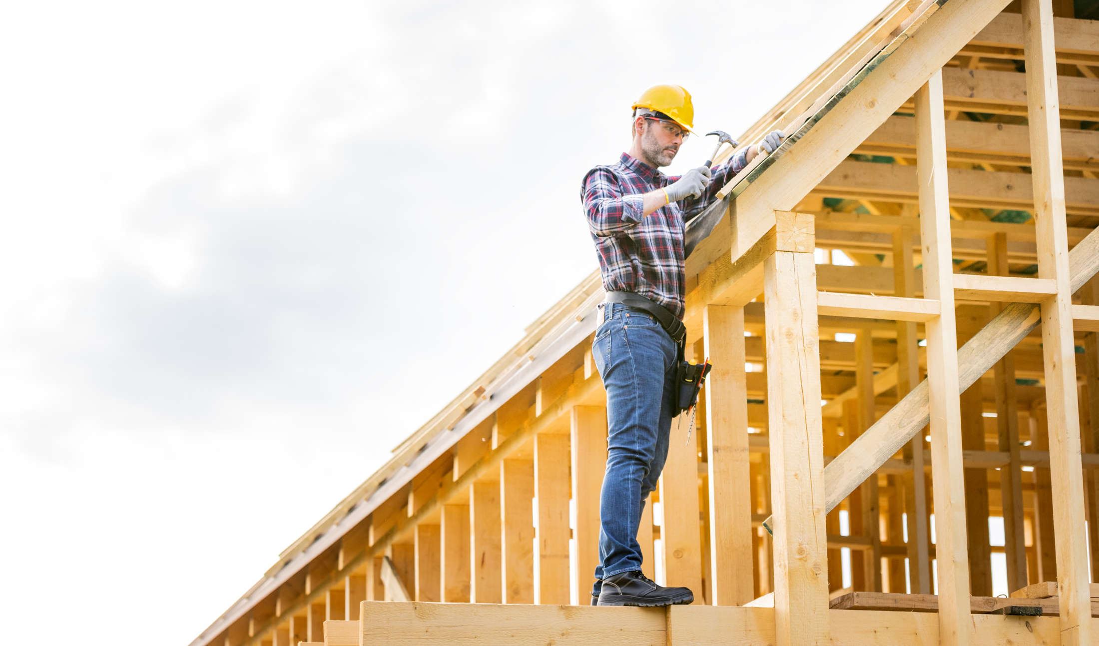 roofer-builder-working-on-roof-structure-at-constr-LW5FL7H.jpg
